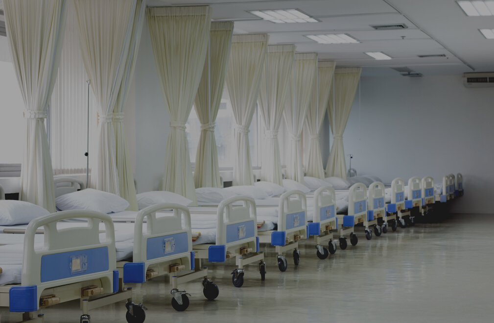 Hospital ward with beds and medical equipment.